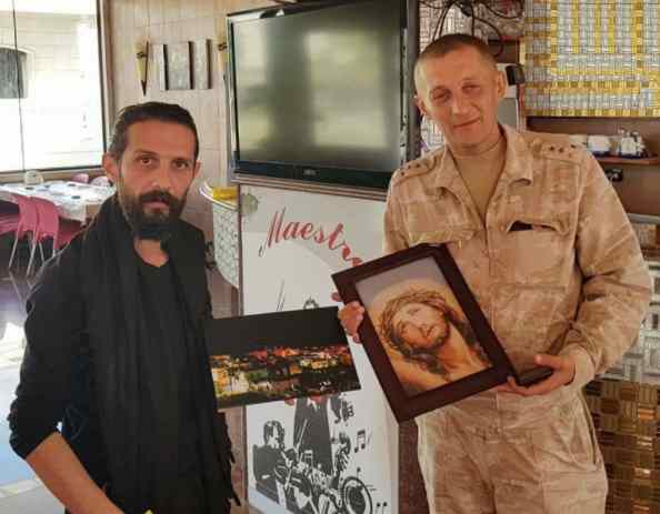 NDF commander in Suqaylabiyah, Nabel Abdulah, meets with a Russian army captain holding a picture of Jesus Christ.